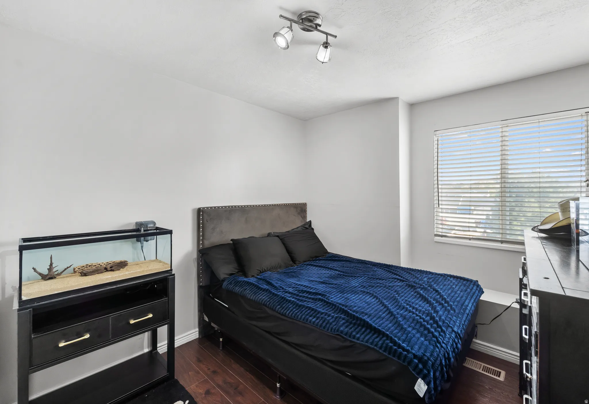 Hardwood-finish flooring, recessed window, window blinds, and overhead track lighting