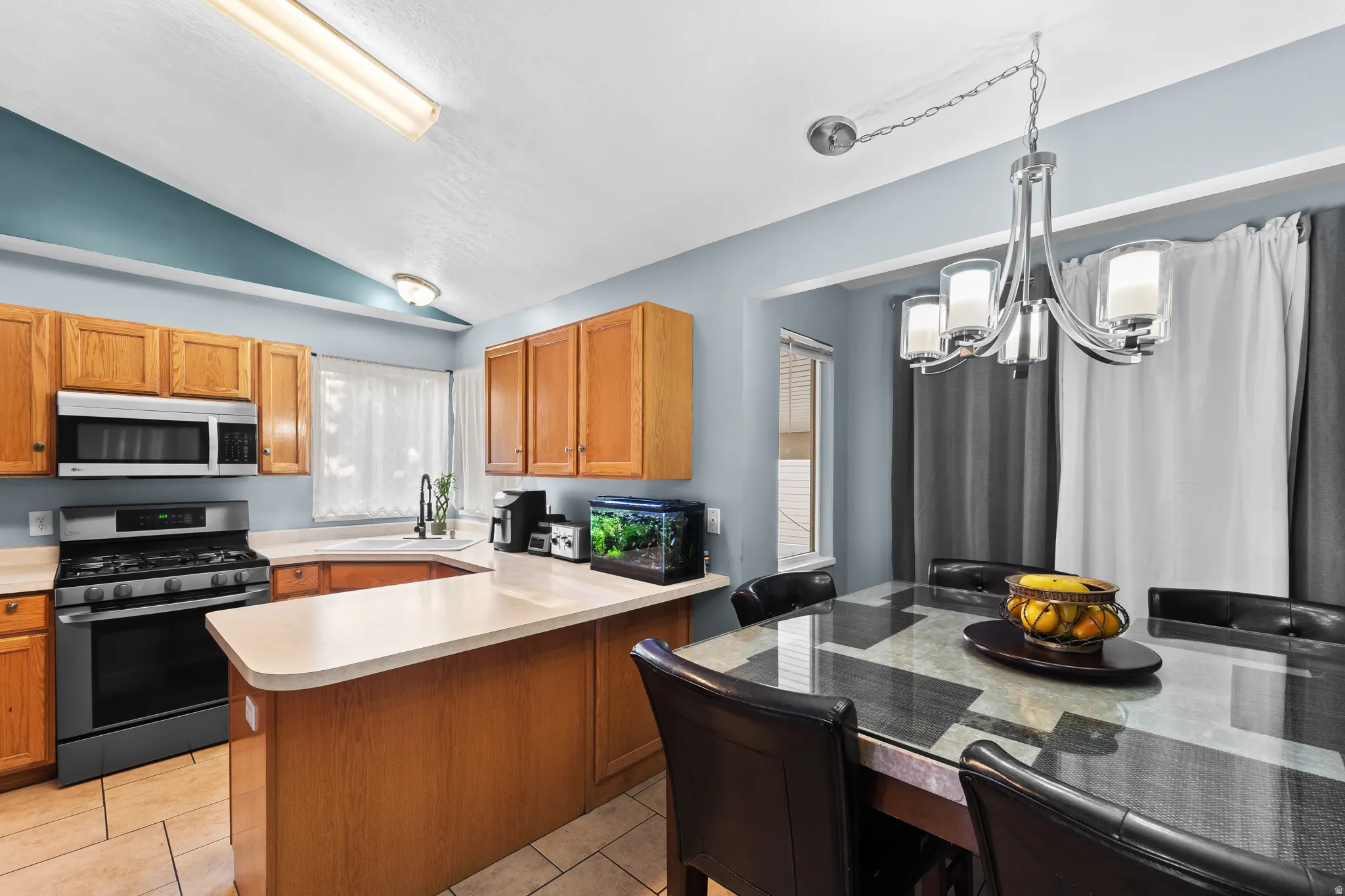 Kitchen featuring wood cabinetry, stainless steel appliances, and a breakfast bar
