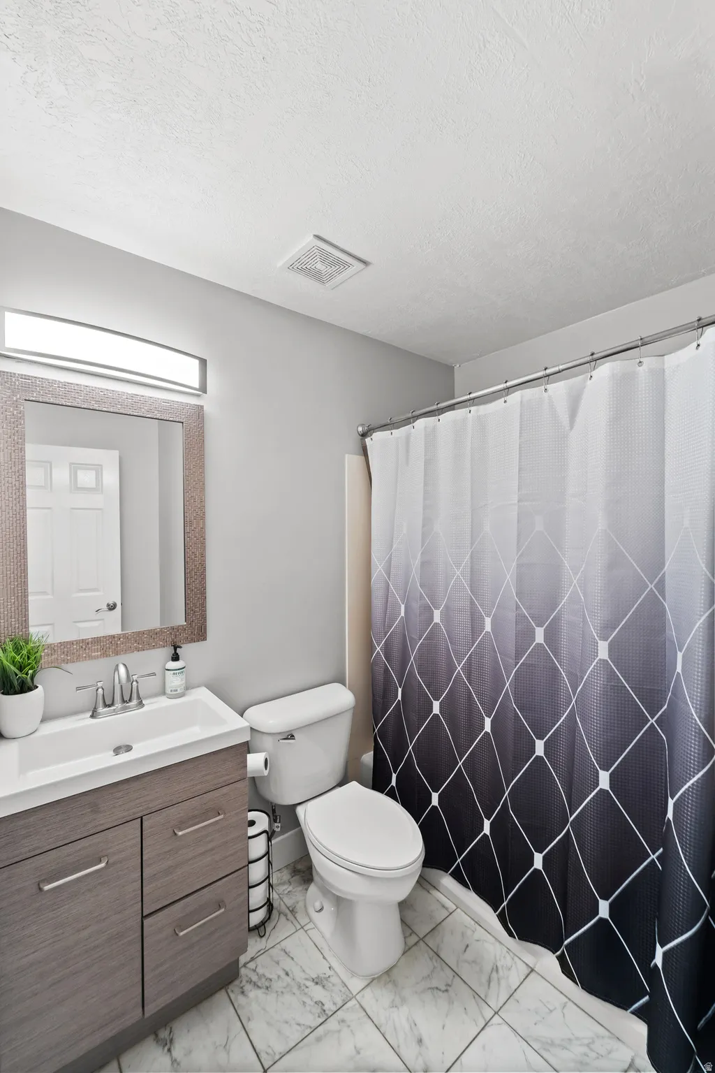 Modern vanity with integrated sink, brushed nickel faucet, and a large framed mirror