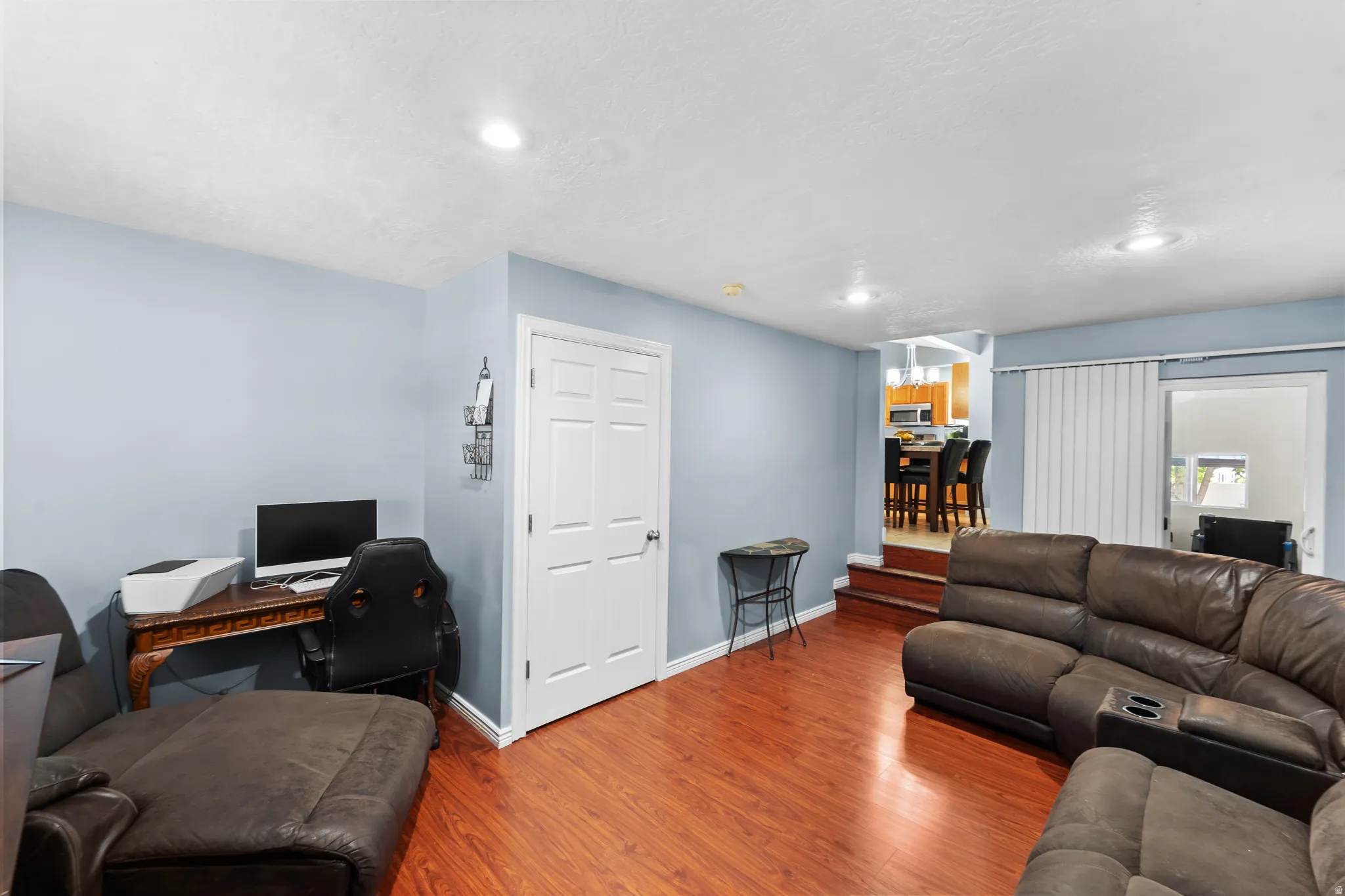Recessed lighting illuminates the wood-finish flooring