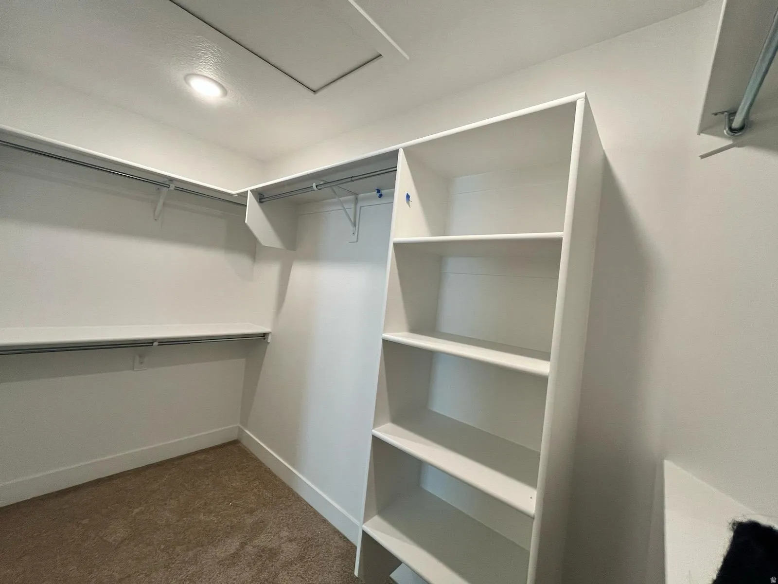 Walk-in closet featuring built-in shelving, multiple hanging rods, and recessed lighting