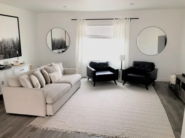 Living area featuring white walls, recessed lighting, and wood-finish flooring