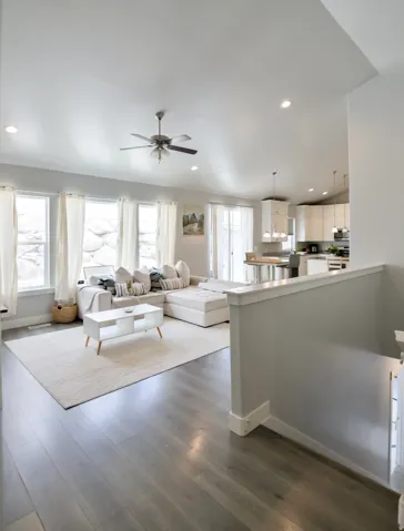 Open-concept living space featuring wood-finish flooring, recessed lighting, and a vaulted ceiling with a ceiling fan