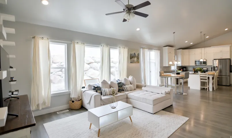 Open concept living area featuring light wood-finish flooring, recessed lighting, and a vaulted ceiling