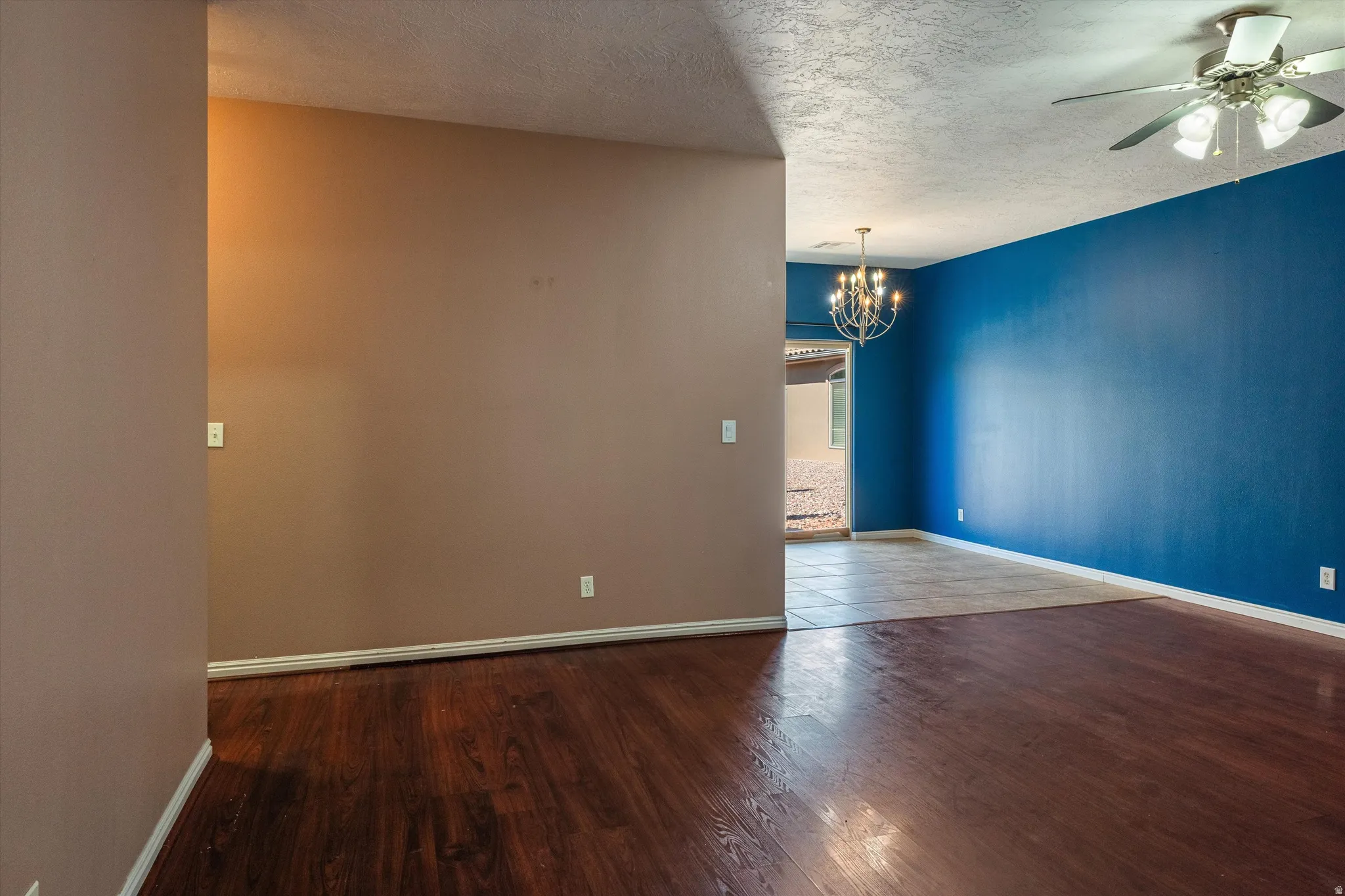 Interior space featuring rich wood-finish flooring and a contrasting tile floor