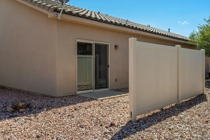 Exterior patio access with a sliding glass door, a stucco finish, and a tile roof
