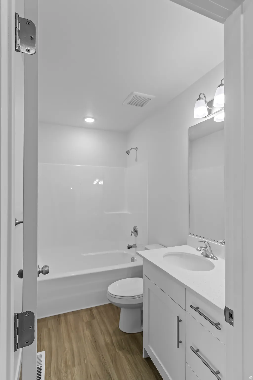 Contemporary bathroom featuring a white vanity with a single basin sink, white countertop, and brushed nickel hardware