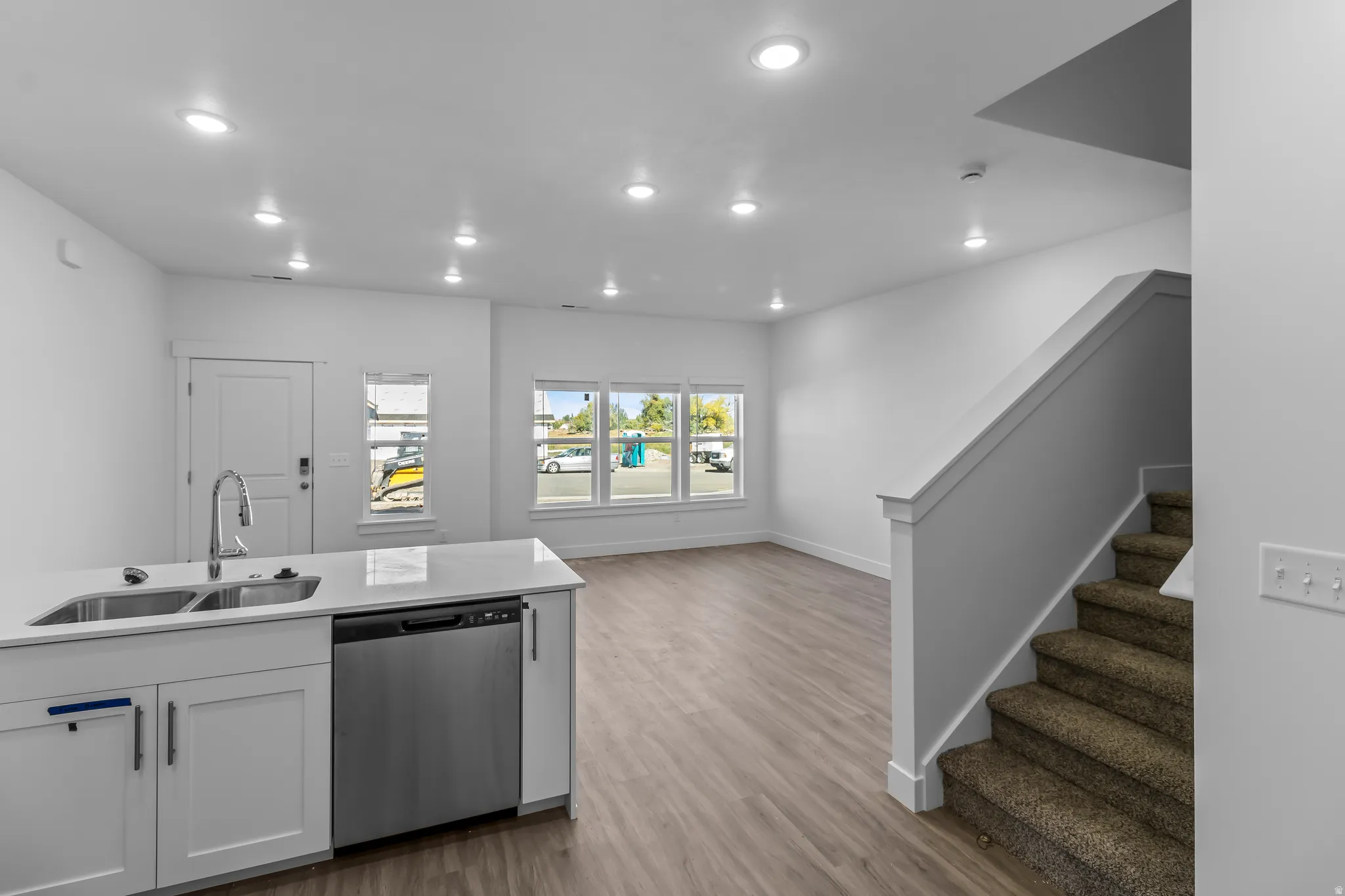Open-concept living space with recessed lighting, wood-finish flooring, and a contemporary kitchen island