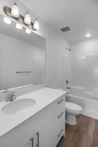 Bathroom featuring a white vanity with an integrated sink, polished chrome faucet, and coordinating hardware