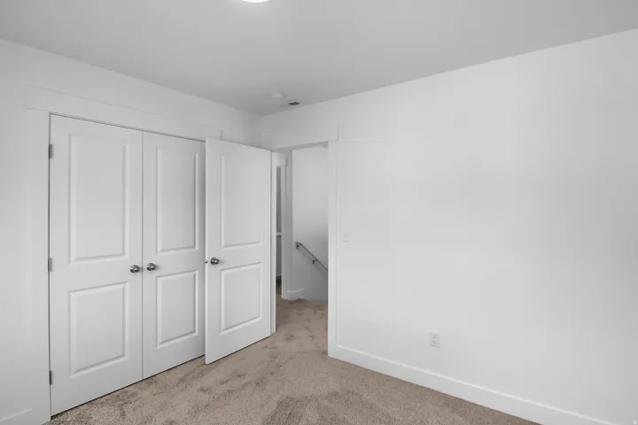 Bedroom featuring neutral-toned carpet flooring, white walls, and a recessed ceiling light