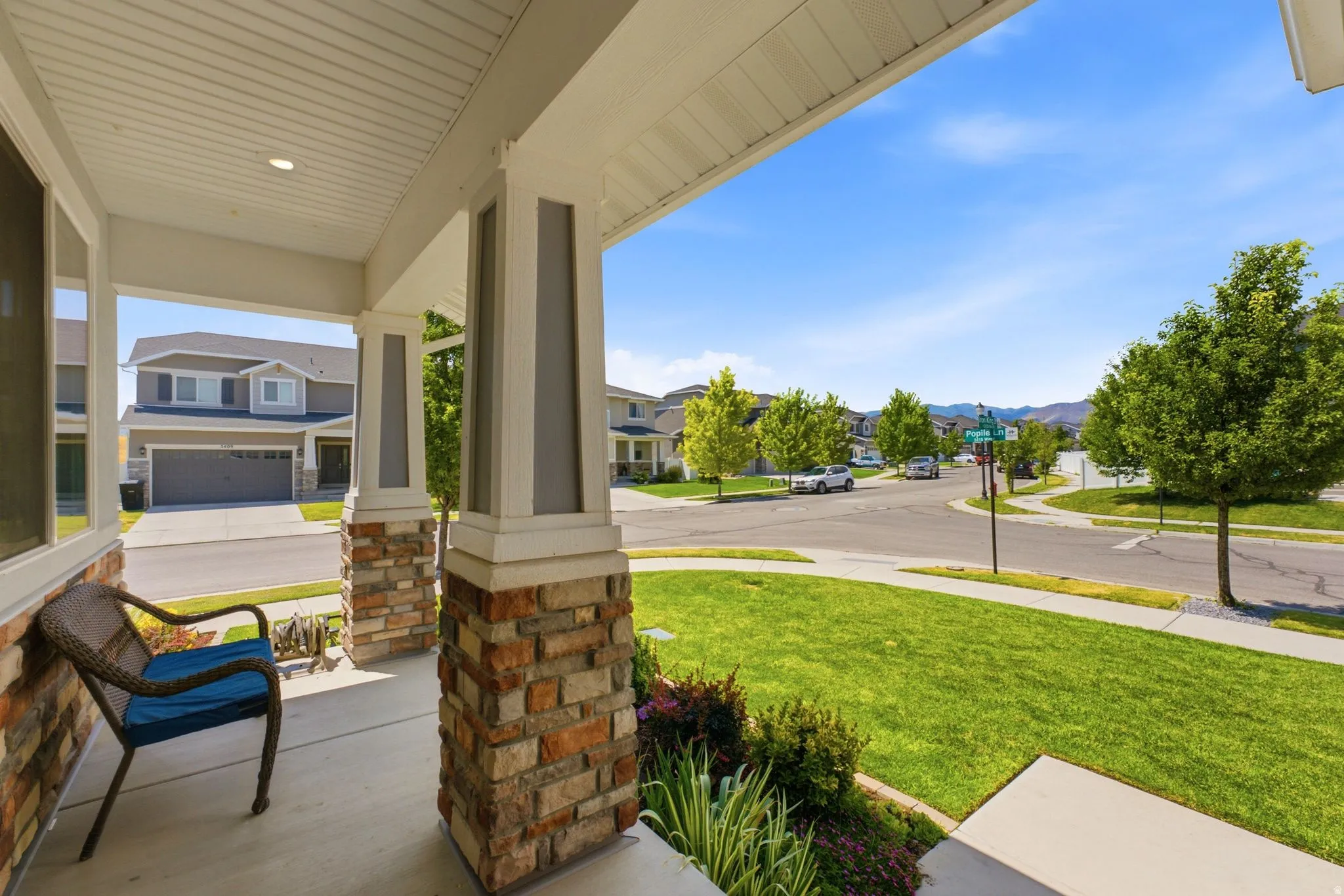 Covered front porch featuring stone and column accents