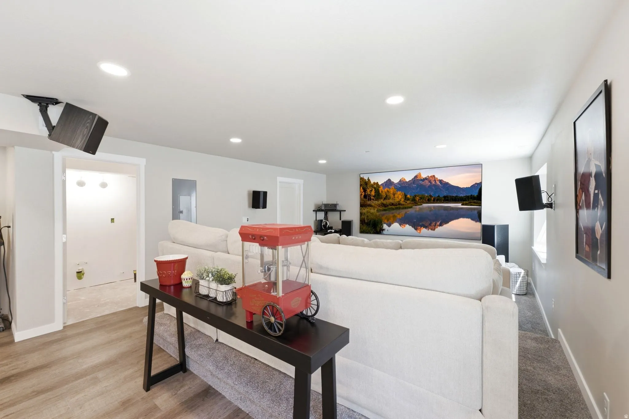 Entertainment room featuring a large projection screen, recessed lighting, and wall-mounted speakers