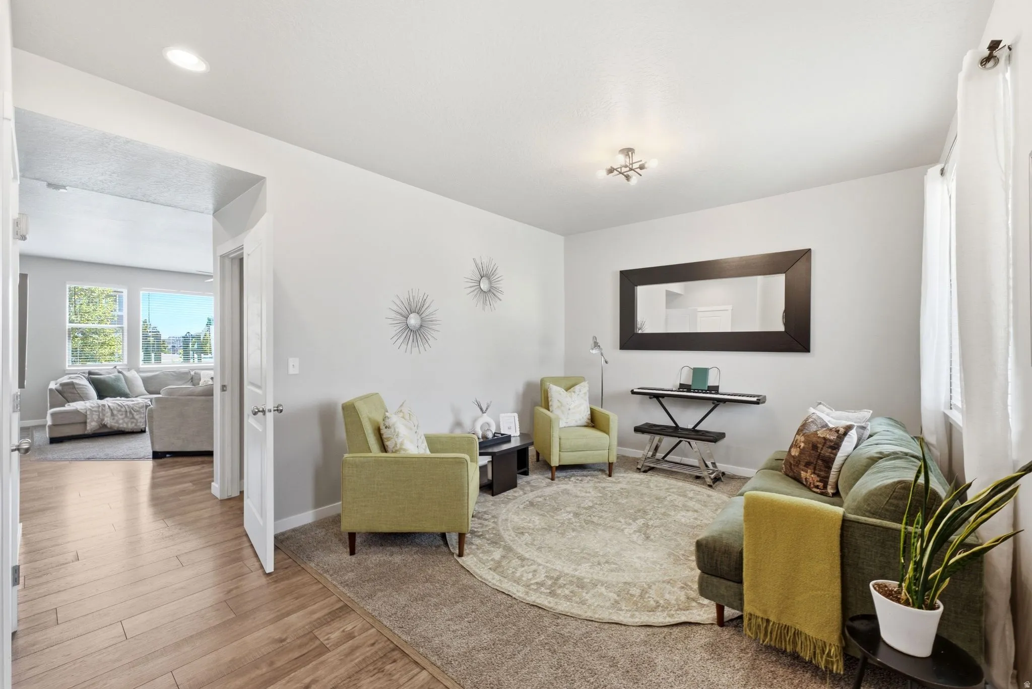 Bright entry area featuring a large wall mirror and a window with sheer white curtains