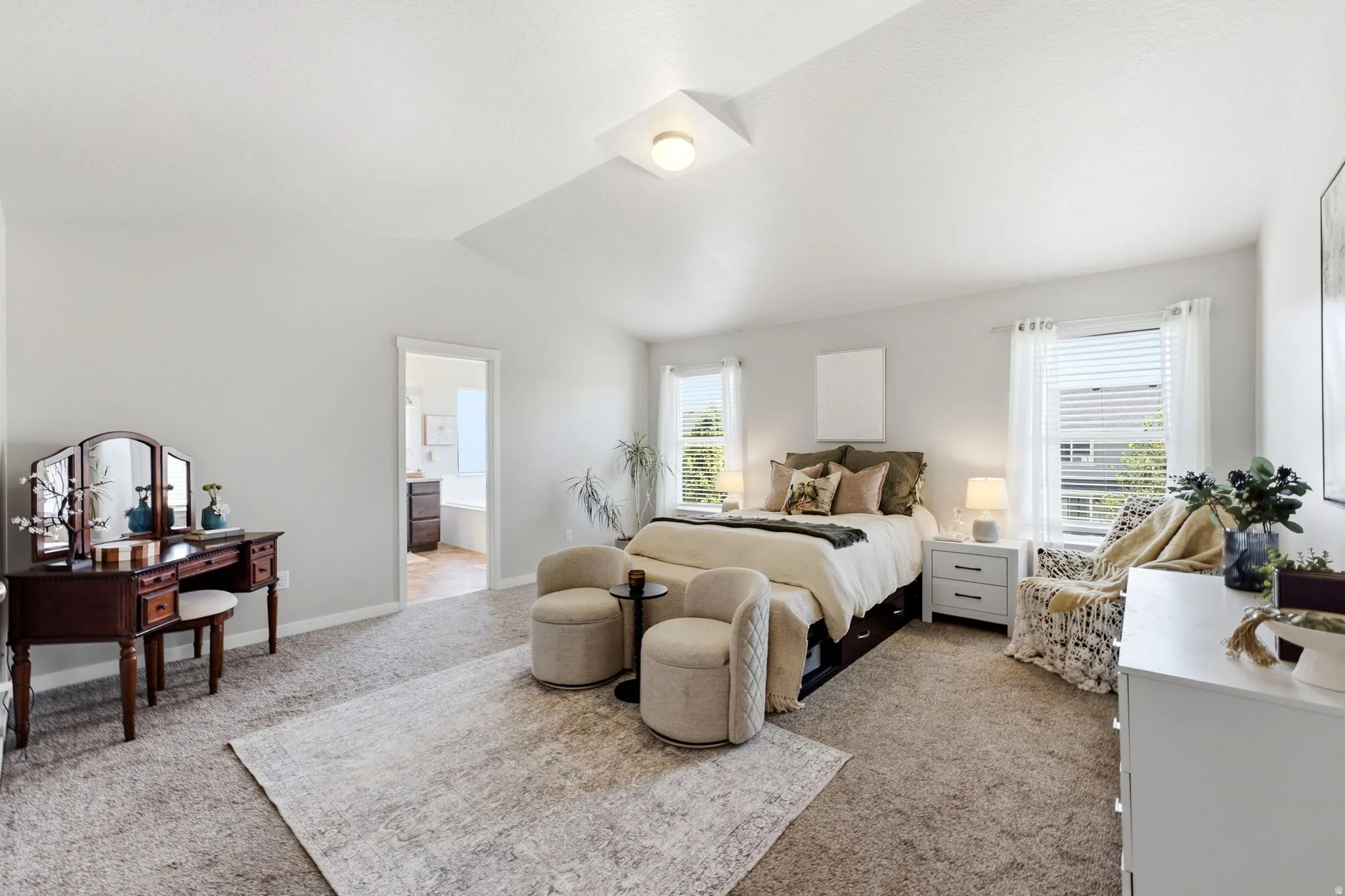 Spacious room featuring vaulted ceilings, light-toned walls, and plush carpeting