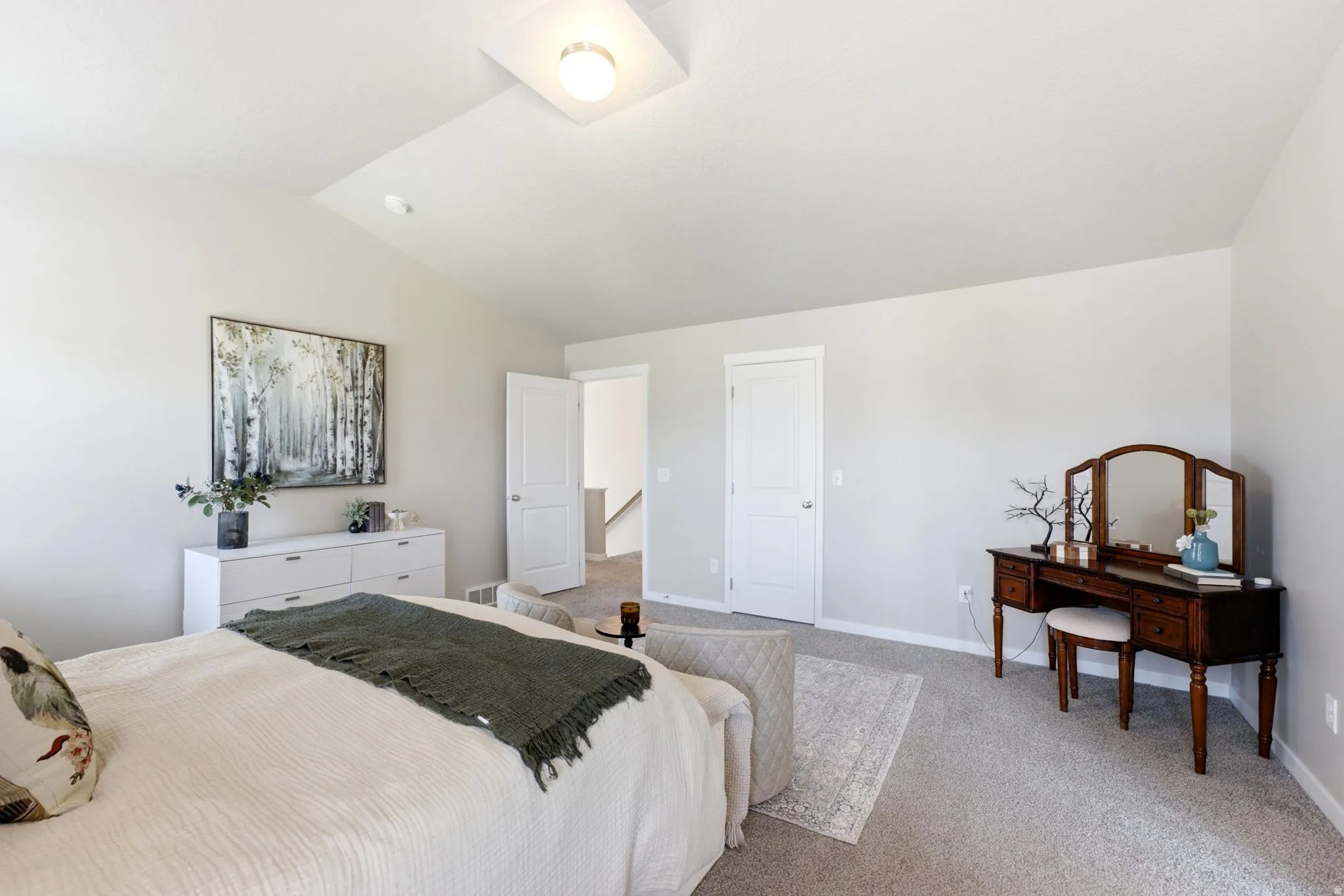 Vaulted ceiling bedroom featuring light gray walls, plush gray carpeting, white trim, and a contemporary ceiling light fixture