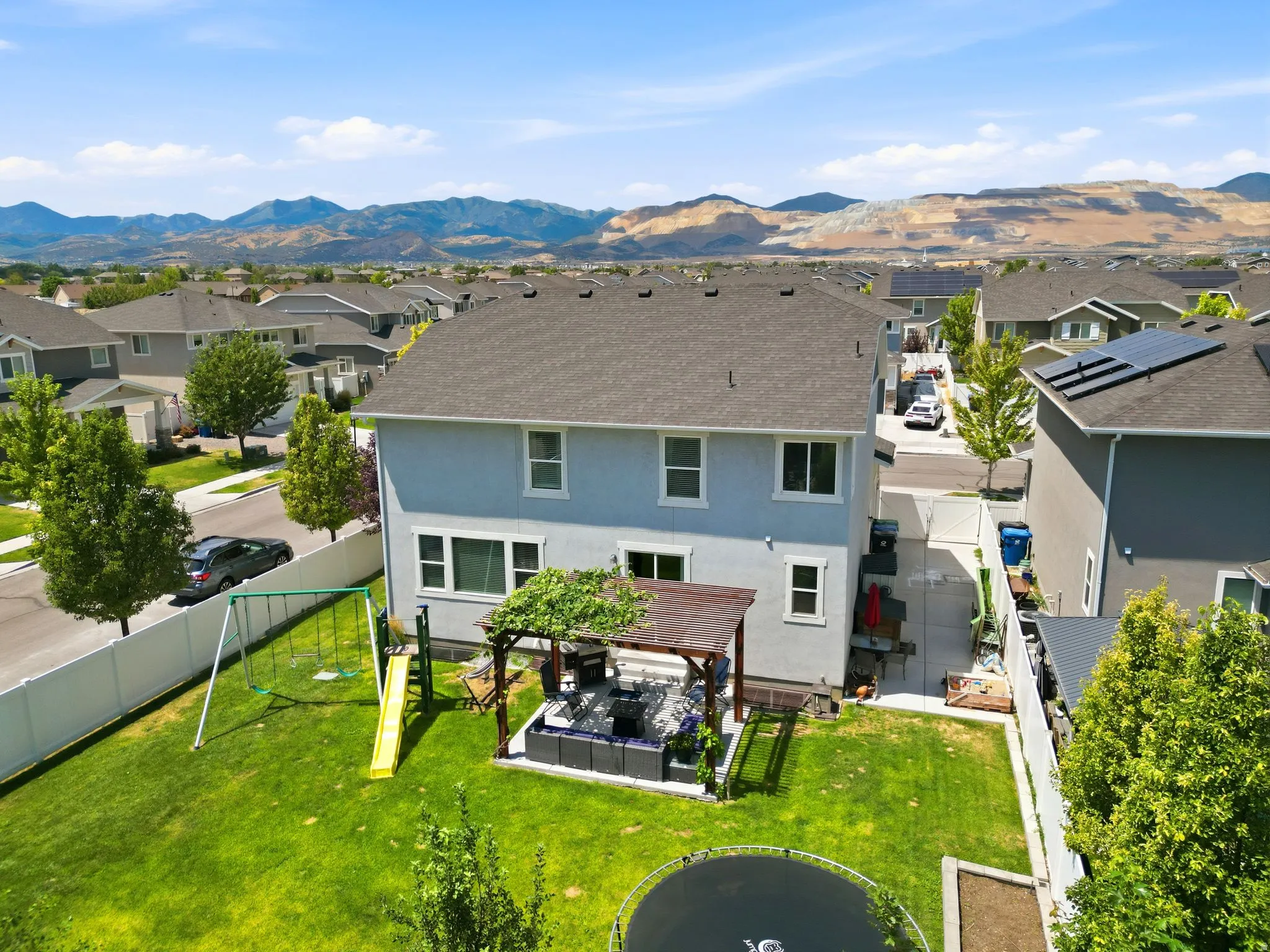 Spacious backyard featuring a manicured lawn, a built-in pergola, and a privacy fence