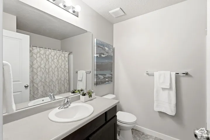 Modern bathroom featuring a single-sink vanity with a light-colored countertop, dark wood-finish cabinetry, and a full-width mirror