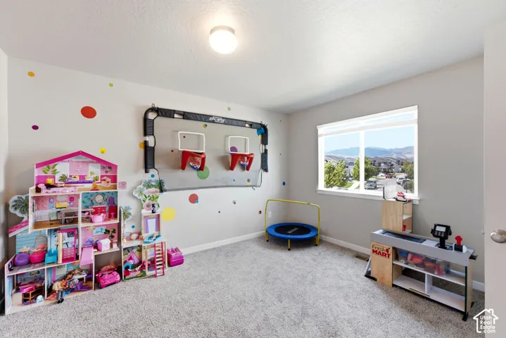 Spacious interior with neutral wall paint, carpet flooring, a large window, and a flush mount ceiling light