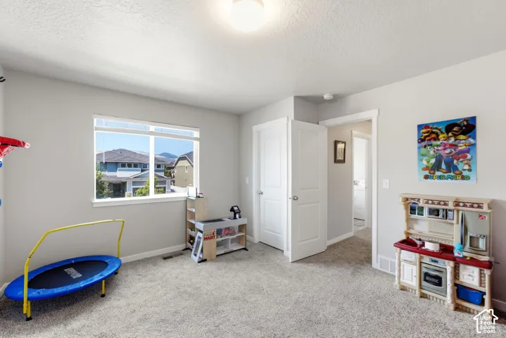Carpeted room featuring a large window, white trim, and two white interior doors
