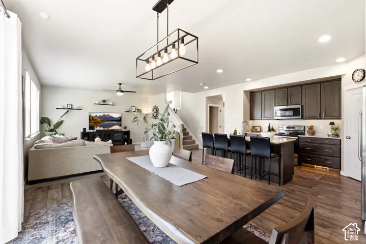 Wood-finish flooring throughout, with a contemporary kitchen featuring dark cabinetry and stainless steel appliances