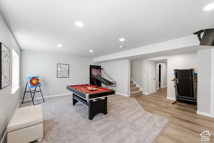 Recessed lighting with light-toned walls, contrasting flooring, and a carpeted area