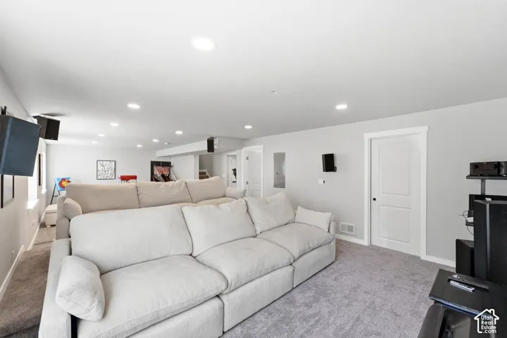 Recessed lighting, light gray wall paint, white trim, two-panel interior doors, and gray carpeting