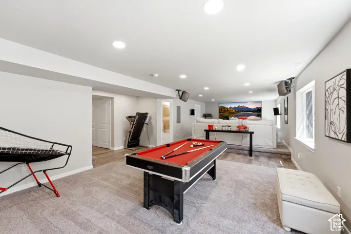 Expansive lower level featuring recessed lighting, a built-in projection screen, and durable carpet and wood-finish flooring