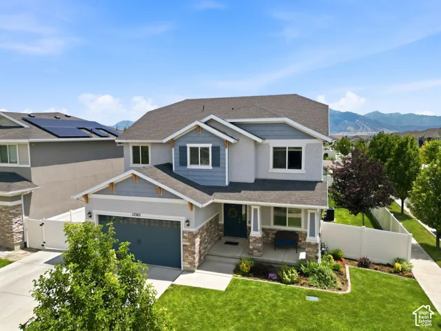 Modern two-story residence featuring a clean architectural design with white and blue exterior finishes, stone accents at the entry, and a two-car garage