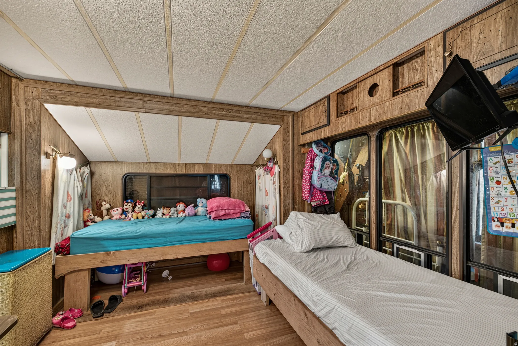Interior space featuring wood-finish wall paneling, ceiling panels, and wood-finish flooring