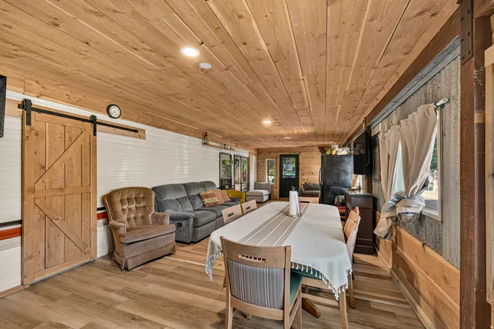 Wood-finish flooring throughout, complemented by a natural wood plank ceiling with recessed lighting