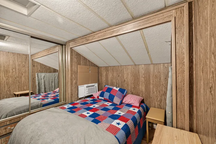 Room featuring wood paneling, a drop ceiling, and a window air conditioning unit