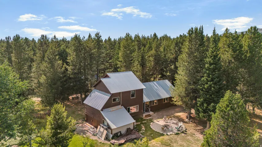 Rustic timber-frame residence nestled within mature evergreen forest