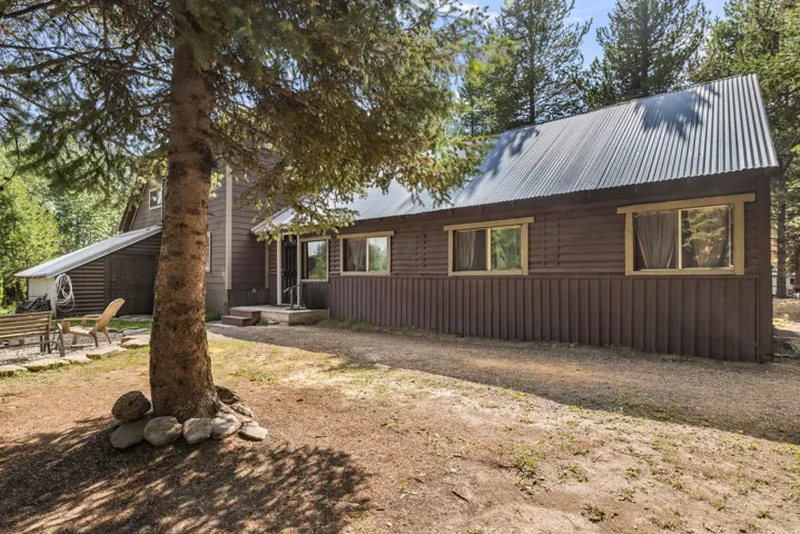 Wood-sided exterior featuring a corrugated metal roof and multiple windows with wood trim
