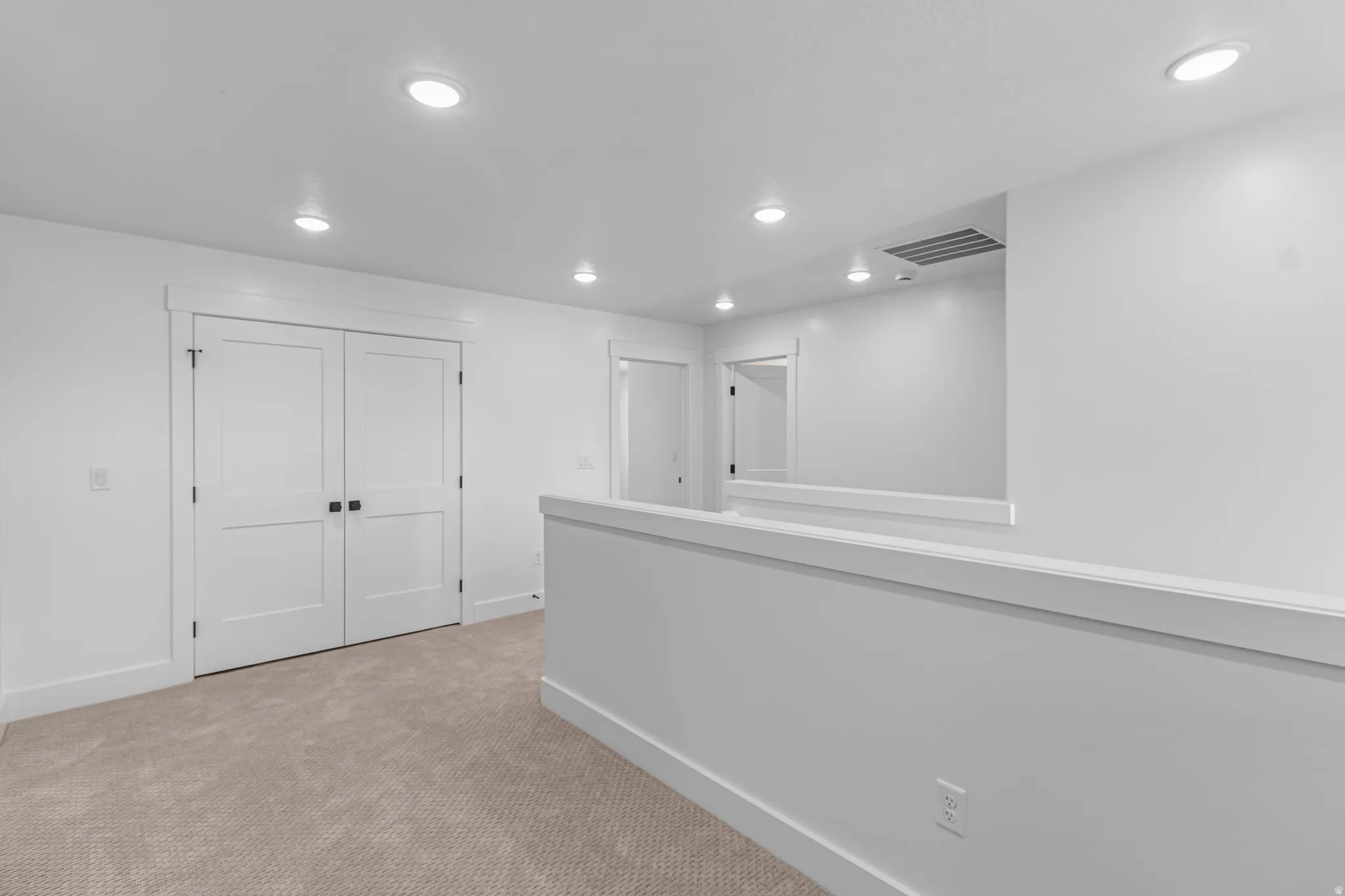 Neutral-toned carpeted flooring with recessed lighting