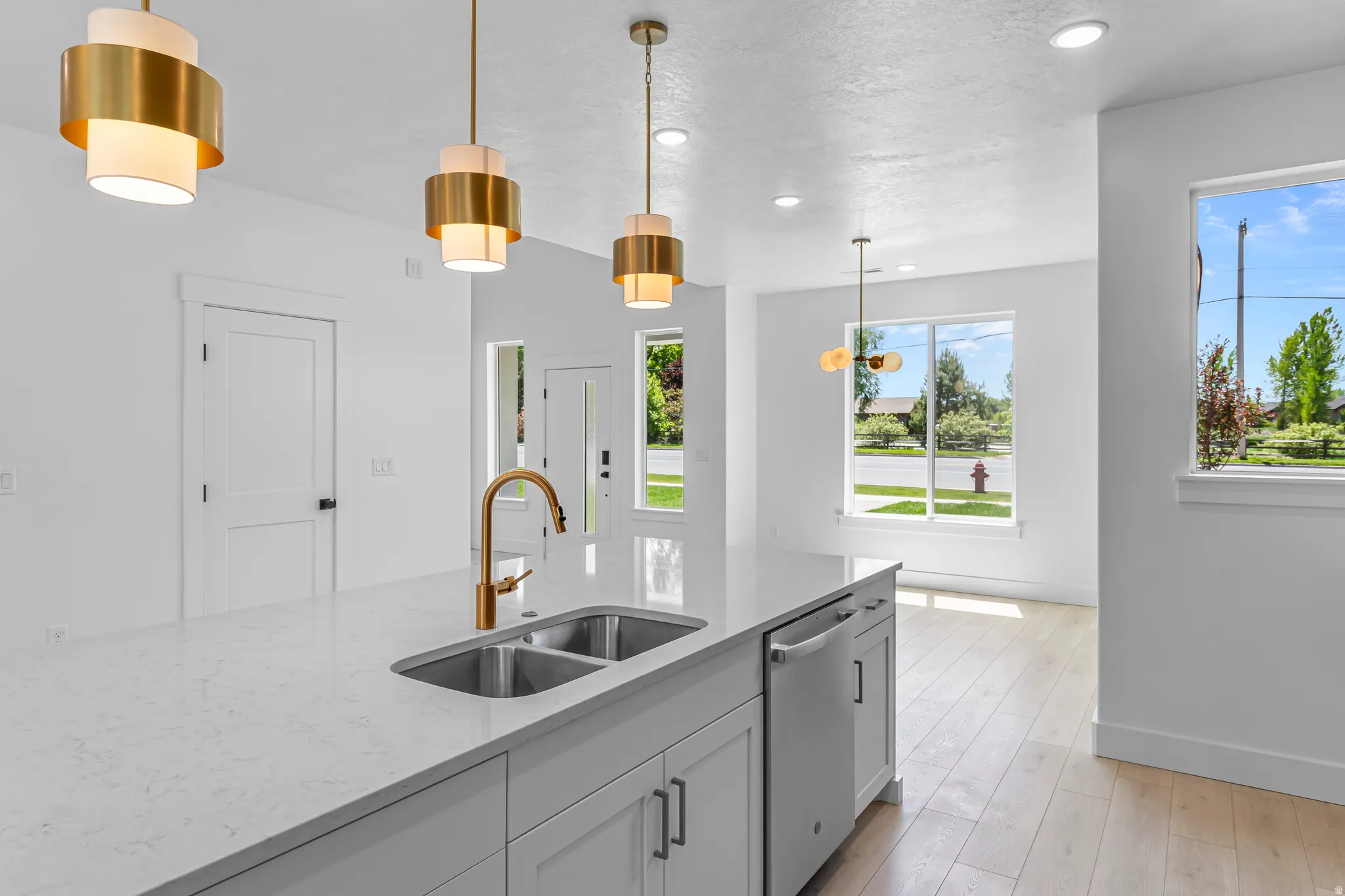 Kitchen island with a double basin sink, brass-finish faucet, and integrated dishwasher