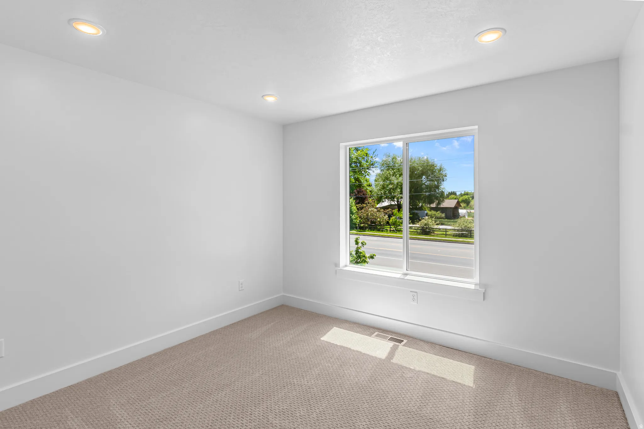 Bright interior space featuring a double-pane window, recessed lighting, neutral carpeting, and white baseboards