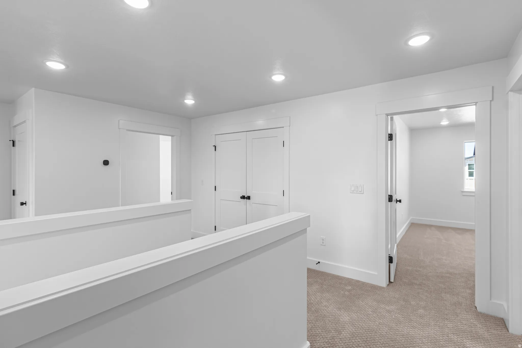 Upper-level hallway featuring recessed lighting, a carpeted floor, white walls, and white trim throughout