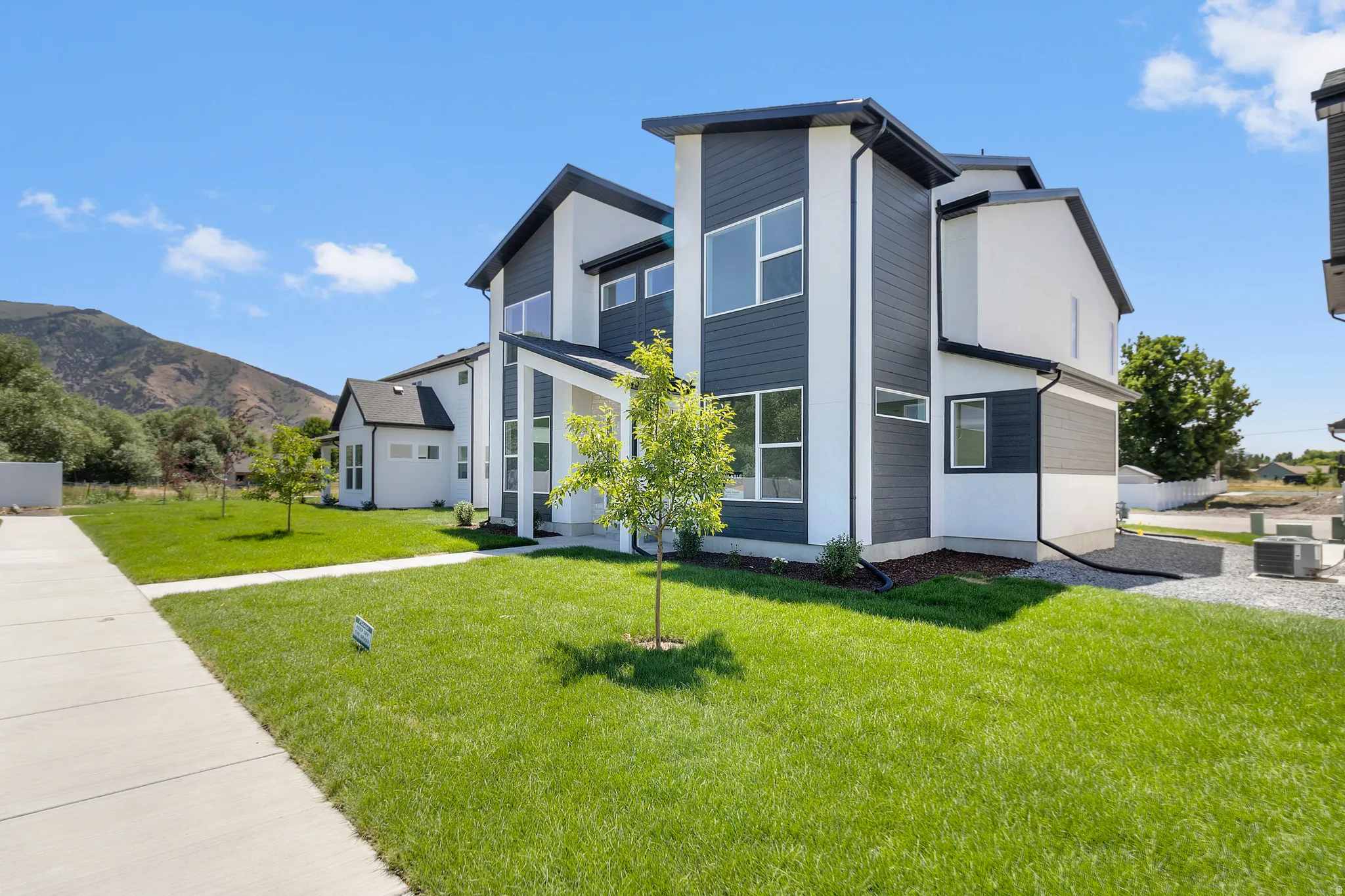 Contemporary multi-level exterior with dark horizontal siding and white stucco accents