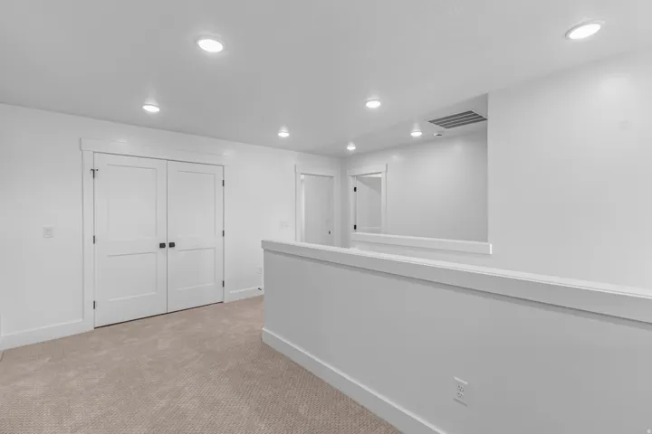 Neutral-toned carpeted flooring with recessed lighting