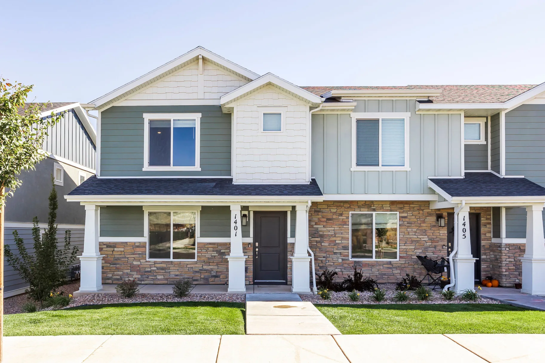 Townhome exterior featuring a combination of stone veneer and horizontal siding