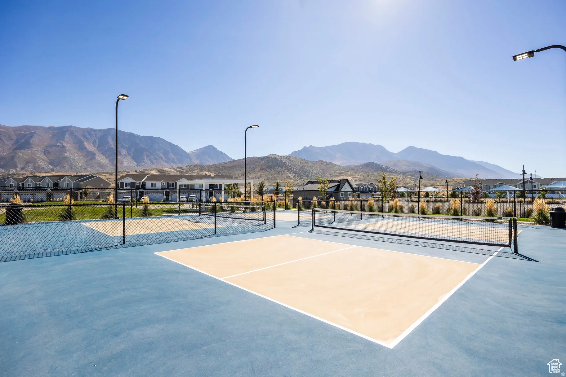 Outdoor court area featuring a blue and beige playing surface with multiple nets
