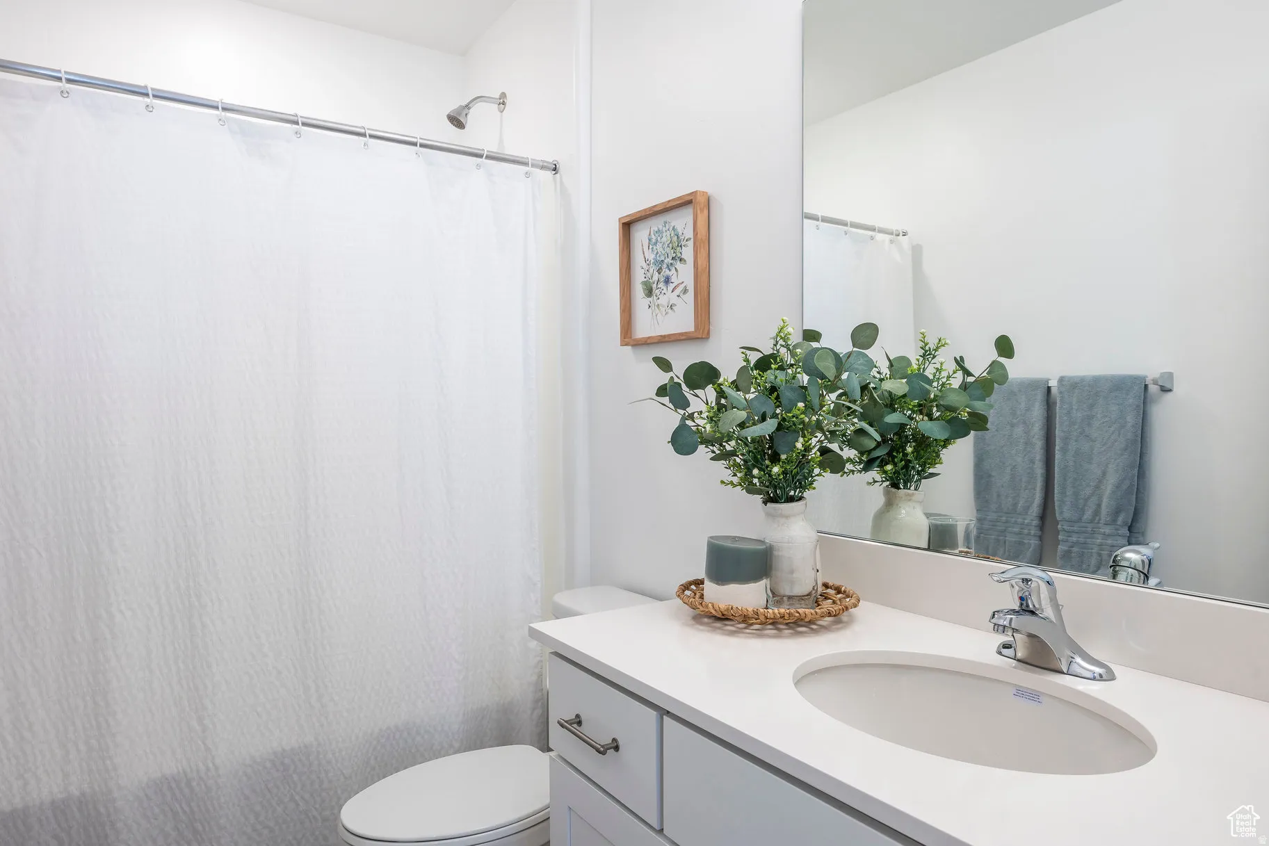 Bathroom featuring a built-in vanity with light countertops, an undermount sink, and chrome fixtures