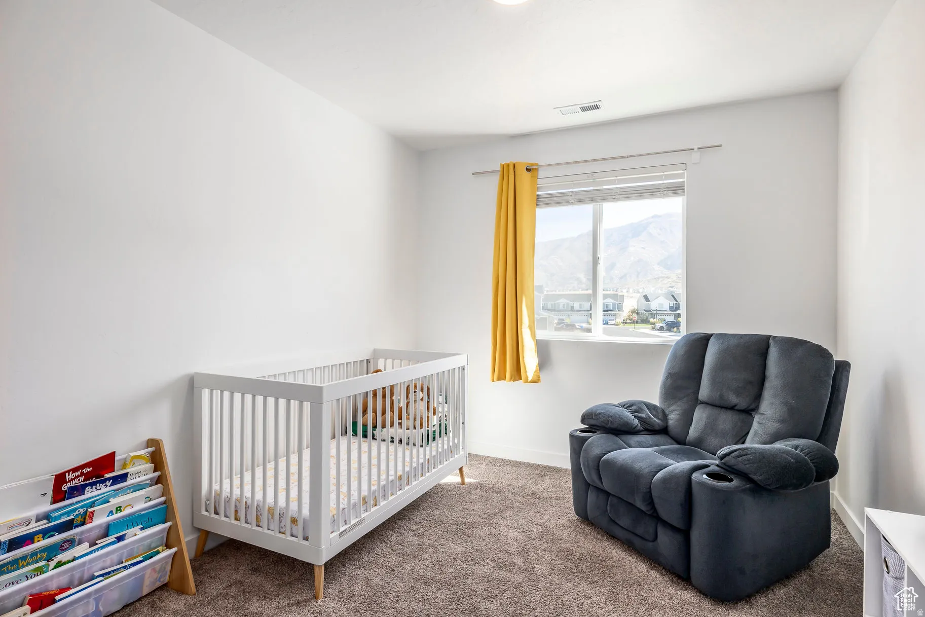 Bright room with neutral wall color and textured carpeting