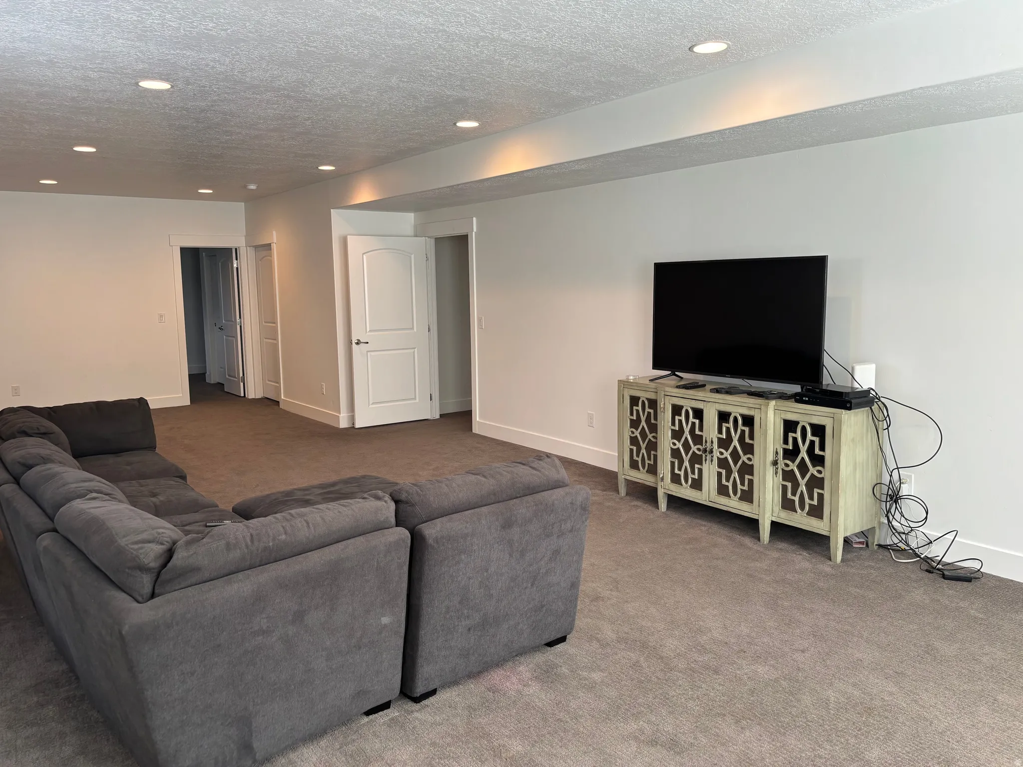Recessed lighting, carpeted flooring, white walls, white interior doors, and modern baseboards