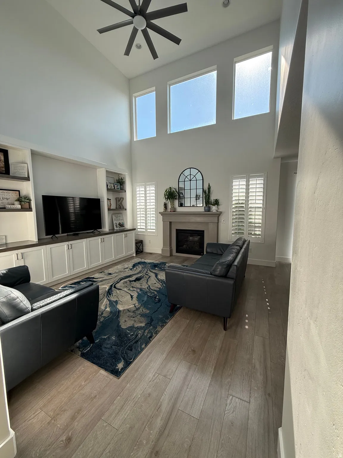 Spacious living area featuring a vaulted ceiling and wood-finish flooring