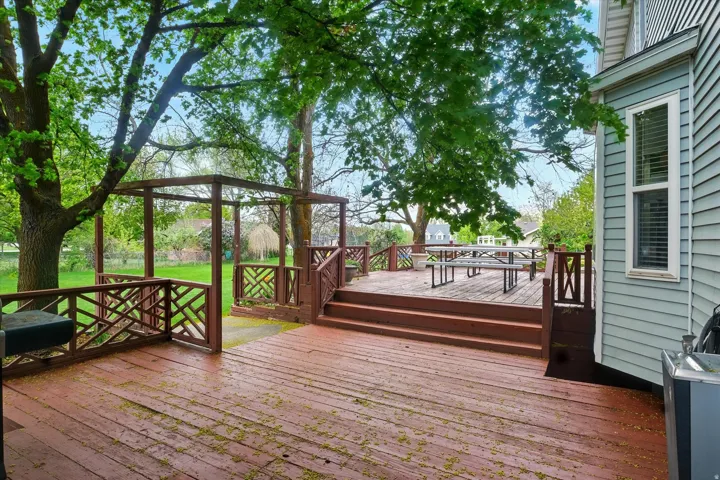 Multi-level wood deck featuring decorative railings and a pergola structure