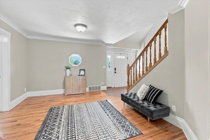 Warm wood-finish flooring complements the detailed staircase with turned wood balusters