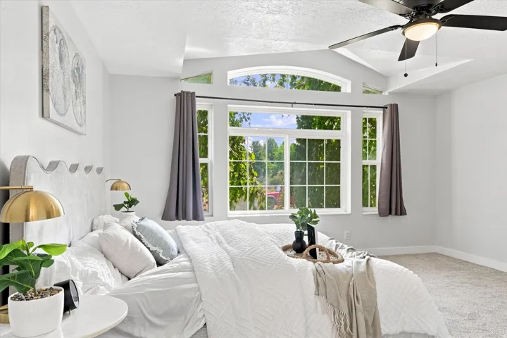 Room featuring a large window array with an arched transom, vaulted ceiling, and carpeted flooring