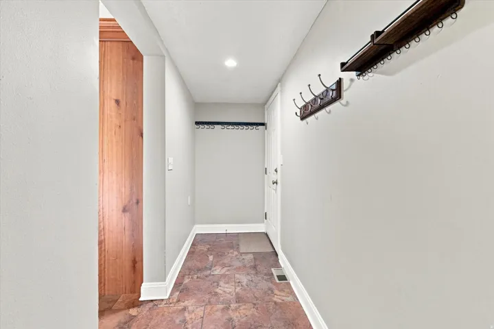 Entryway with tile flooring, light neutral wall paint, and white trim