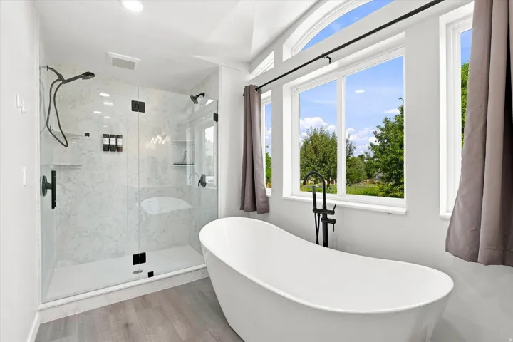 Freestanding soaking tub complemented by large windows and an arched transom window